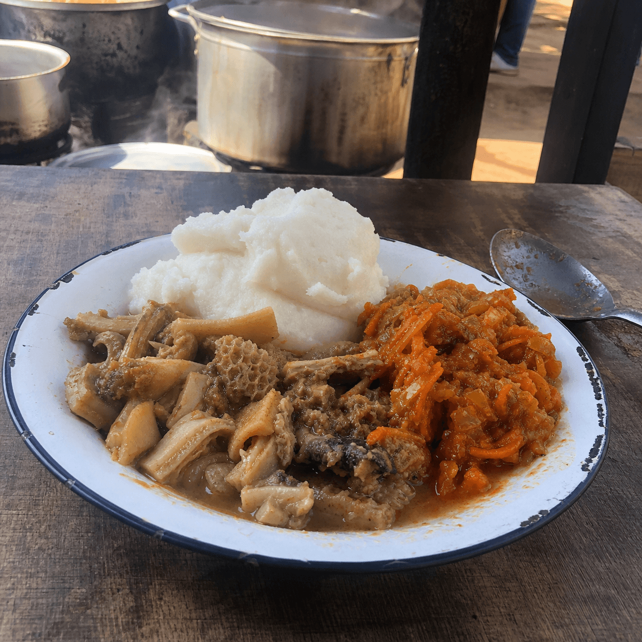 Mogodu with pap and chakalaka on an enamel plate